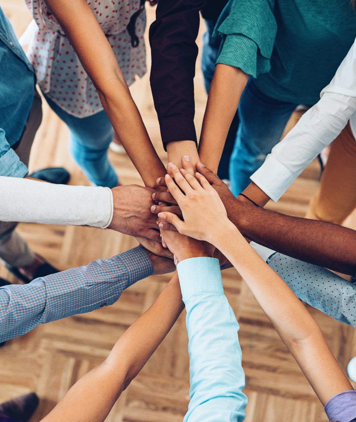 Group of professionals putting their hands in for a team-building activity