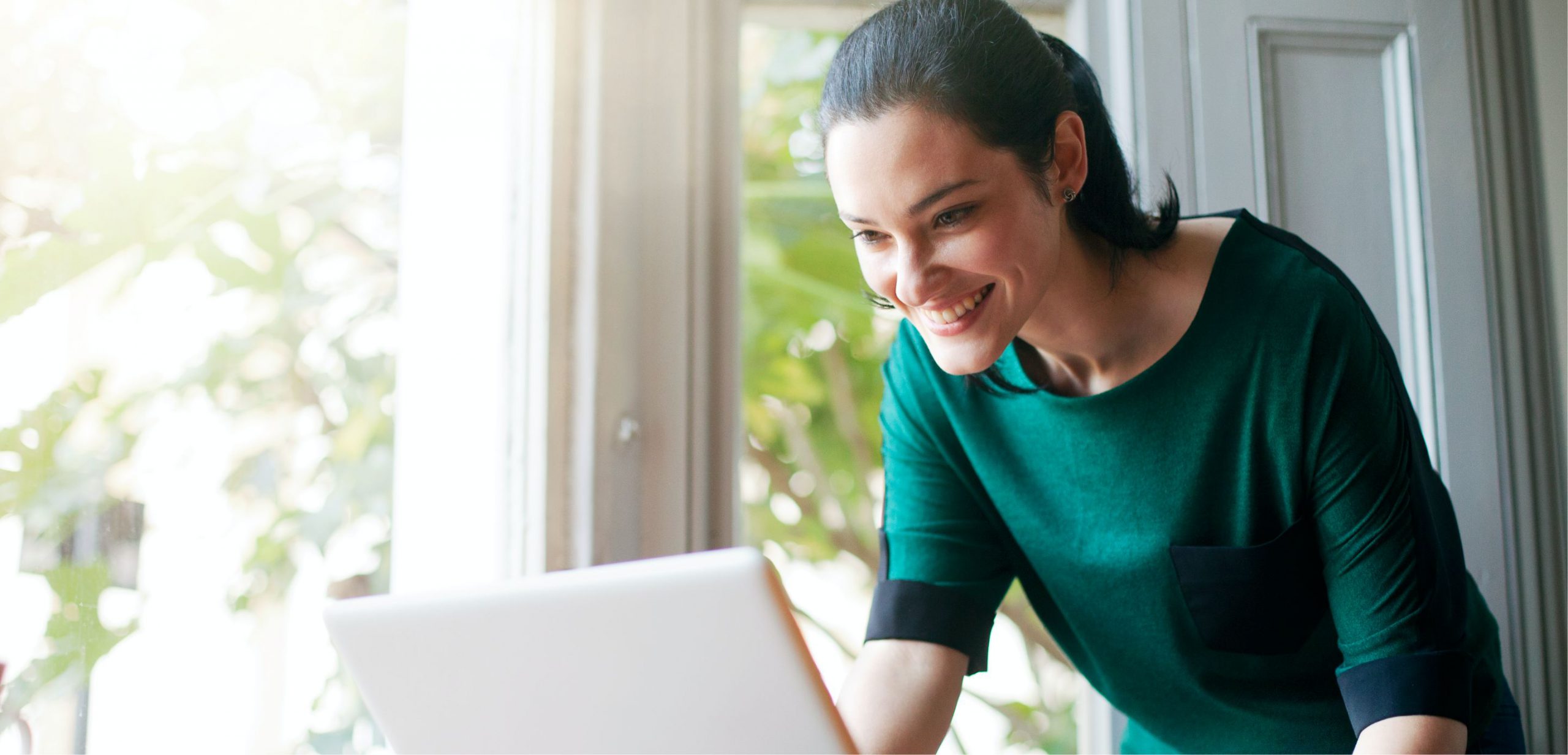 Woman in a green shirt using a laptop