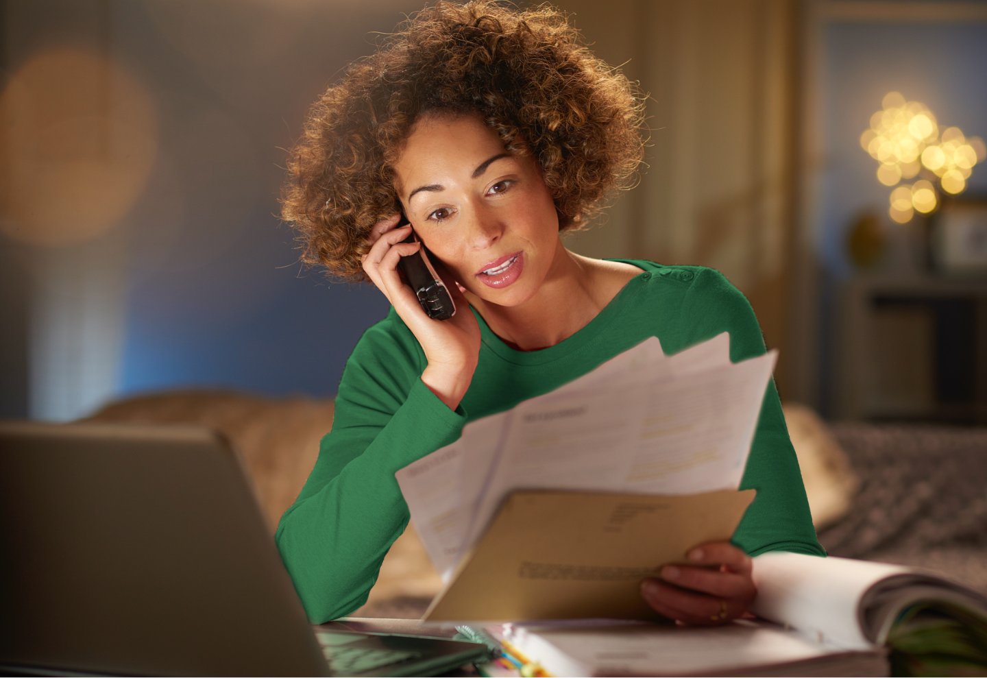 Woman calling to talk about her bills while using her laptop