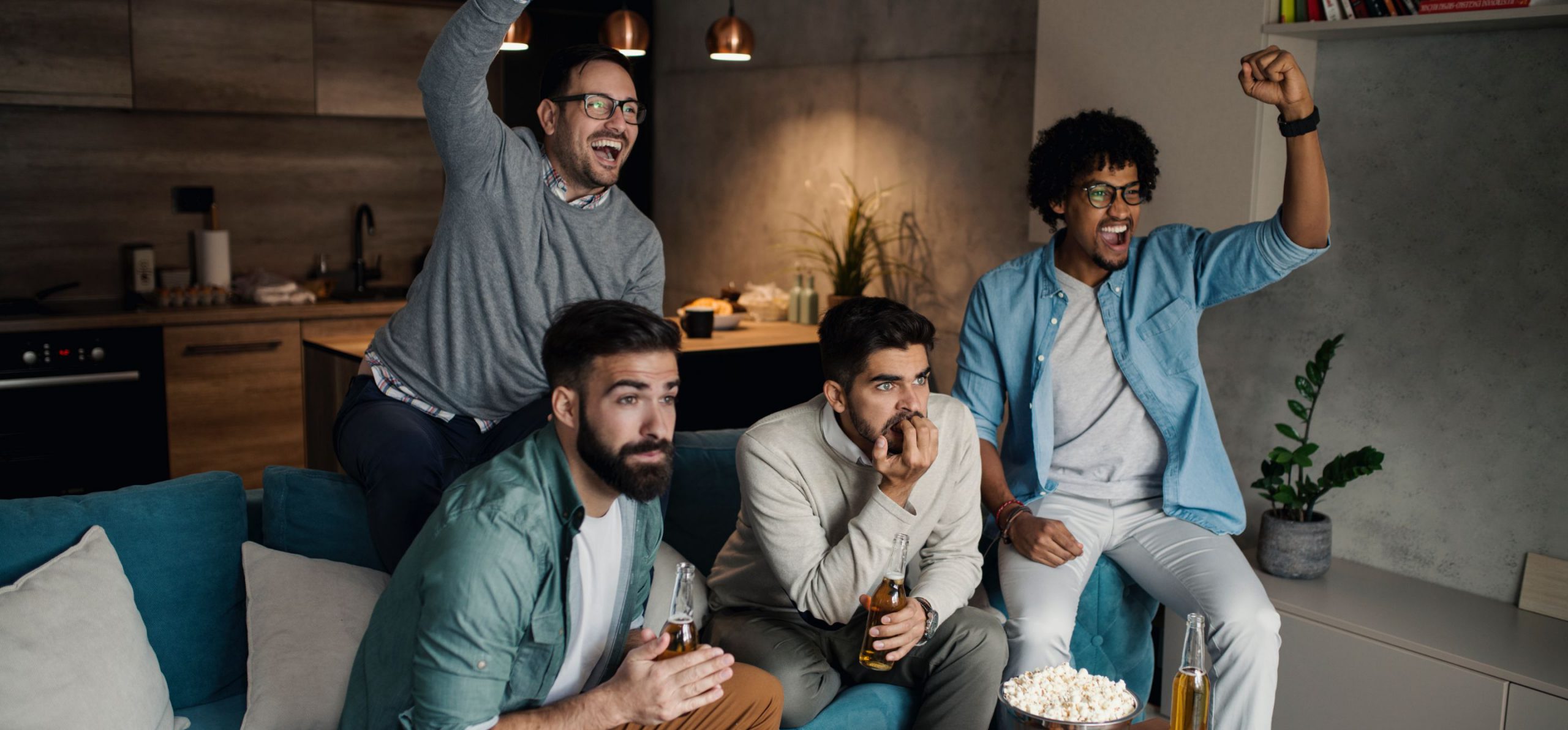 Group of guys watching the sports game while drinking