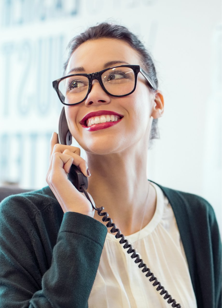 Professional business woman using a corded cell phone at the office