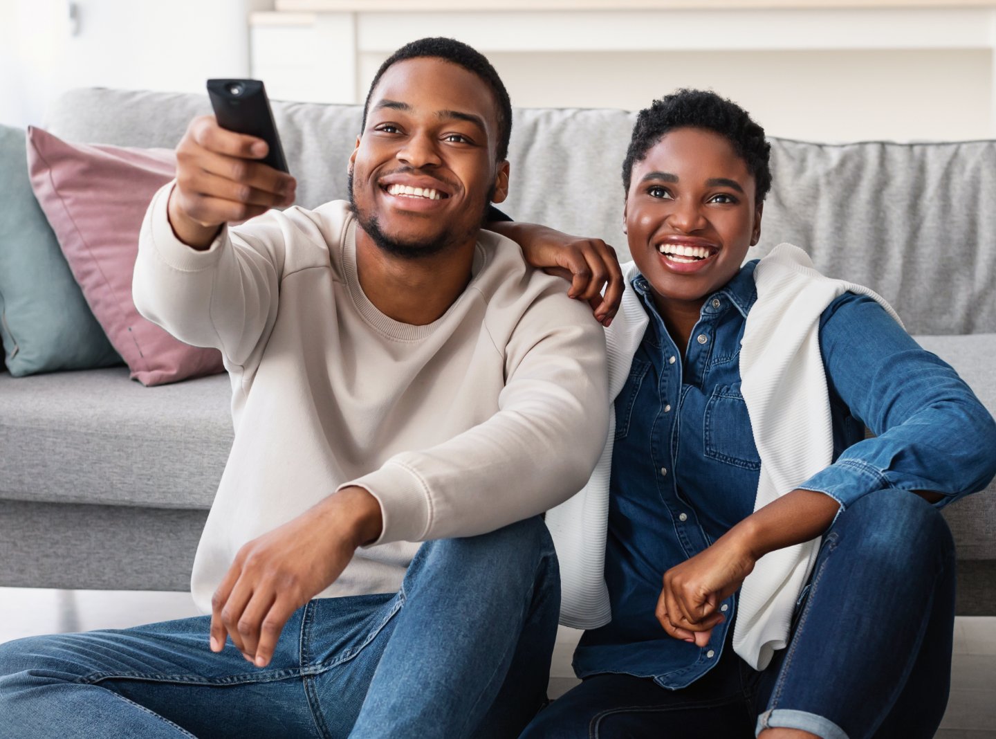 African american couple watching television and holding a remote